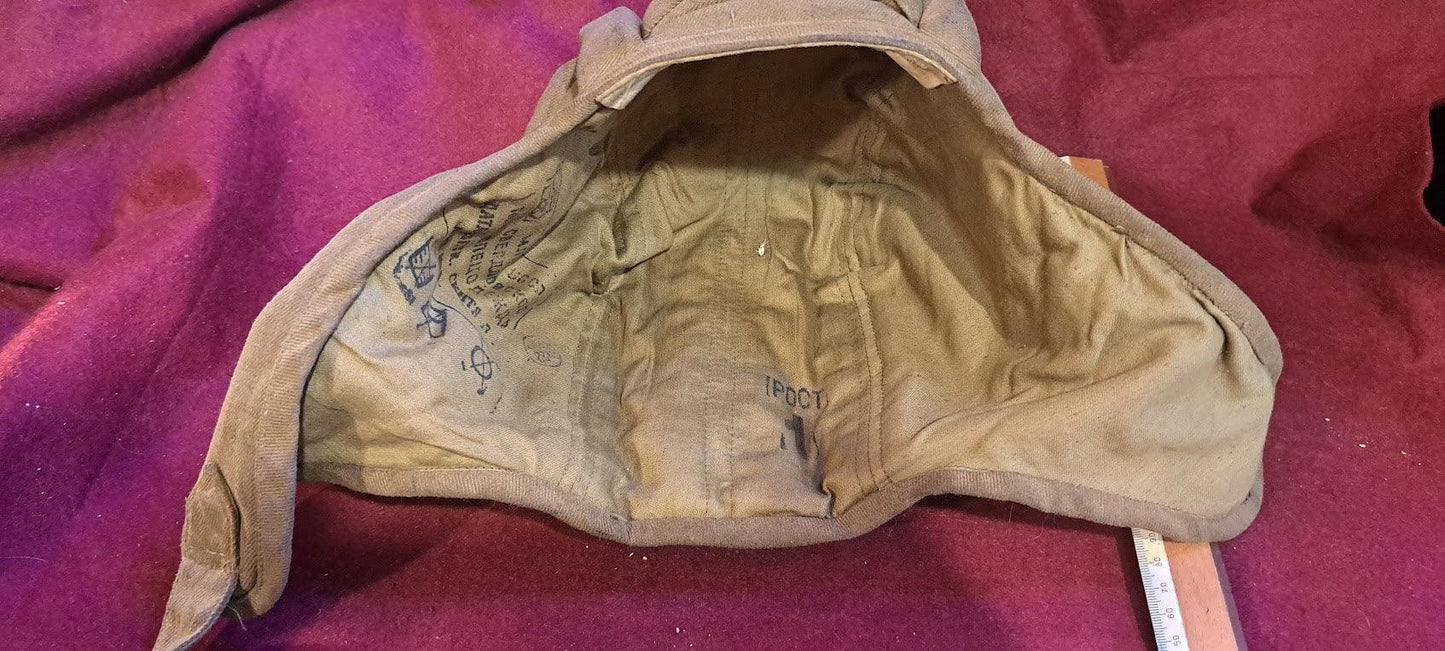 Vintage khaki military hat interior with visible markings on a burgundy fabric background