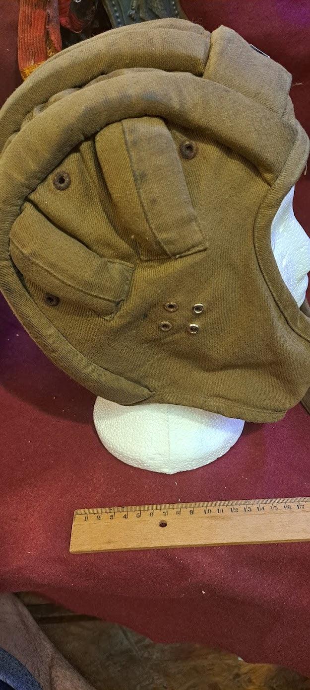 Vintage padded aviator helmet on mannequin head, brown fabric, ruler for scale