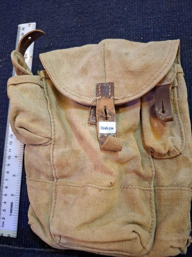 Vintage canvas military satchel with leather straps, ruler for scale, collectible bag