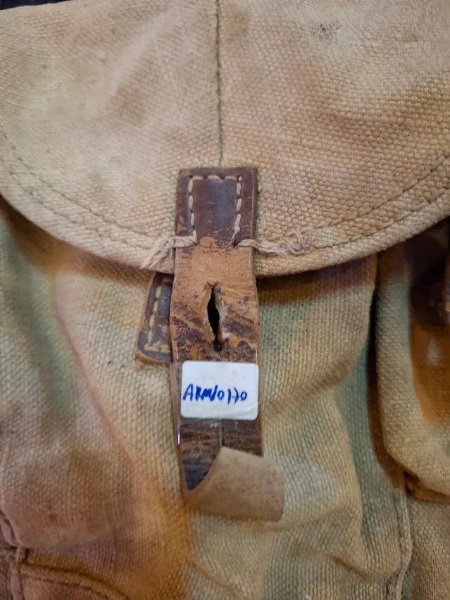 Vintage canvas and leather satchel with worn buckle and handwritten label