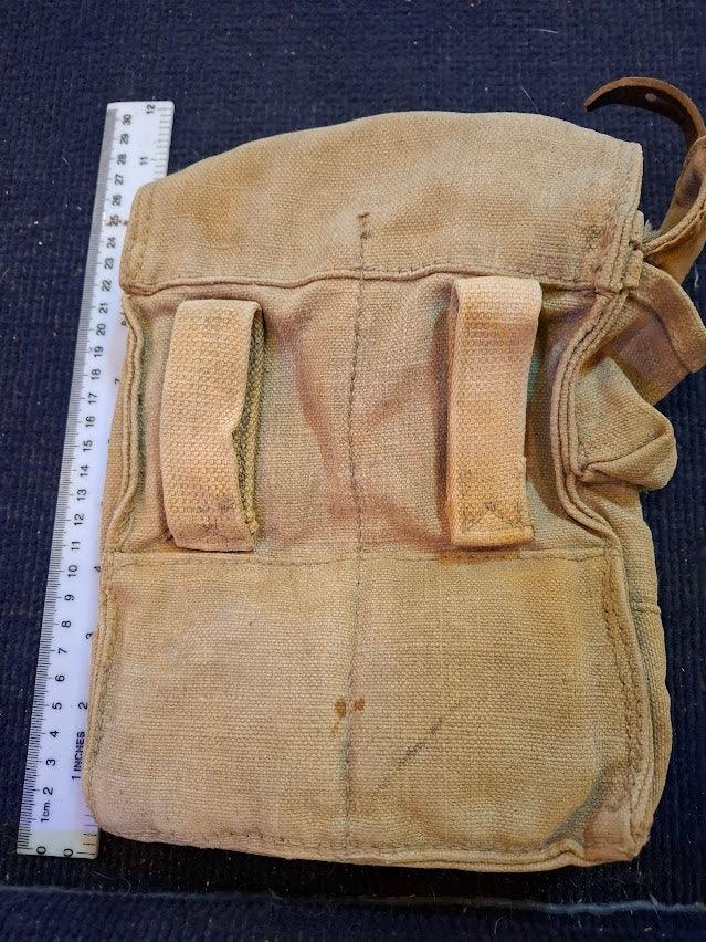 Vintage canvas utility bag with belt loops and ruler for scale on dark surface