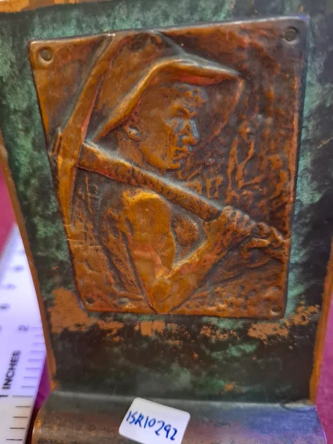 Antique metal bookend with embossed miner design and patina finish