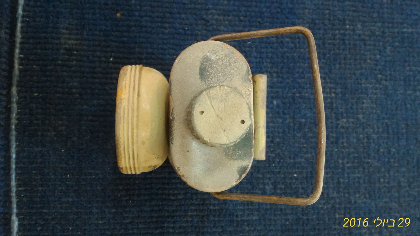 Vintage metal flashlight with a handle on blue fabric background, collectible antique item